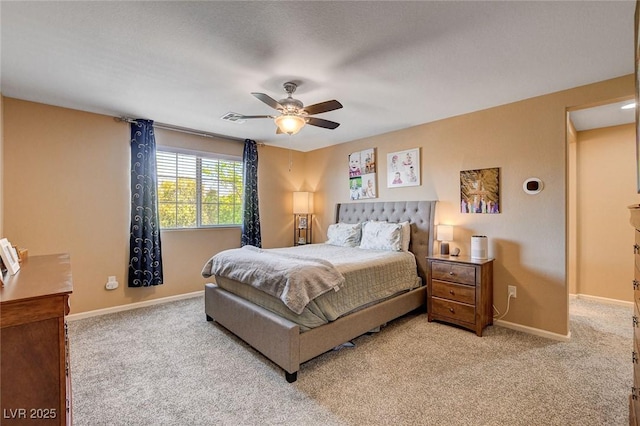 bedroom featuring light colored carpet, baseboards, and a ceiling fan