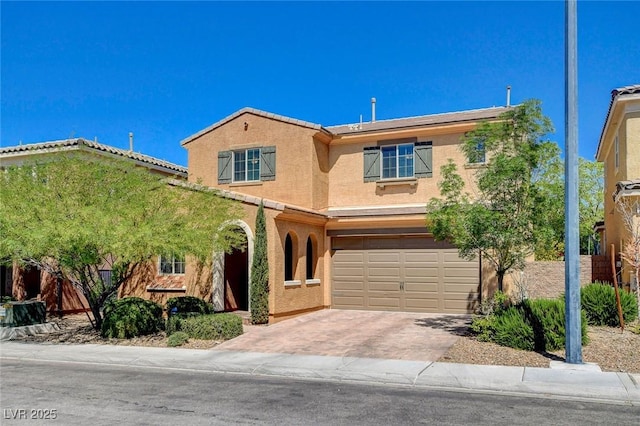 view of front of house with a garage, stucco siding, and driveway