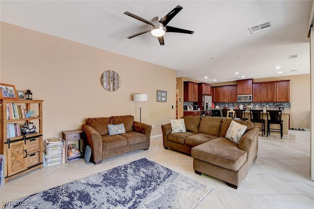 living area with ceiling fan, recessed lighting, and baseboards