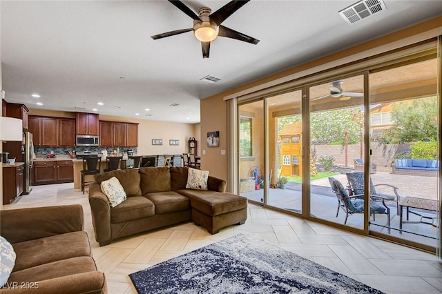 living area with ceiling fan and recessed lighting