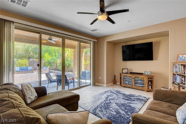 living room with ceiling fan and baseboards
