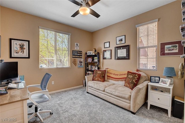 carpeted office with ceiling fan and baseboards