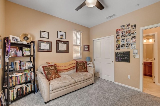 living area featuring ceiling fan, carpet, and baseboards