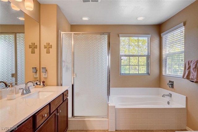 full bath with healthy amount of natural light, a garden tub, vanity, and a shower stall
