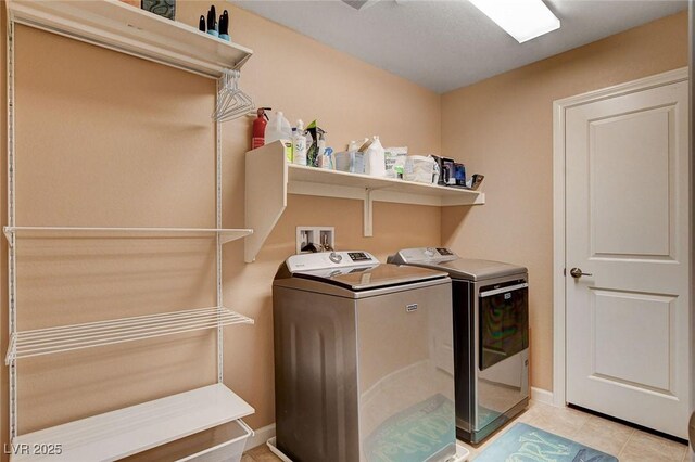 washroom with separate washer and dryer and light tile patterned floors