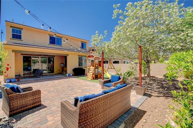 view of patio / terrace featuring a playground, outdoor lounge area, and fence