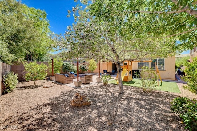rear view of property featuring fence, stucco siding, and a patio