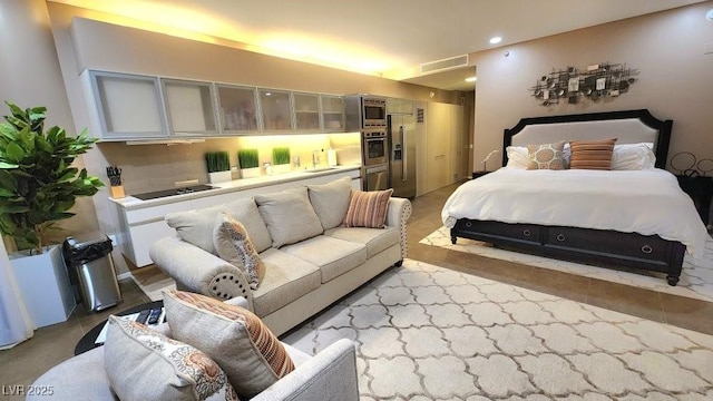 bedroom featuring stainless steel fridge and recessed lighting