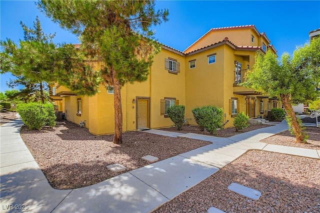 5915 Nuevo Leon St Unit 8, North Las Vegas, NV 89031 - view of front facade with stucco siding, a tile roof, and a balcony