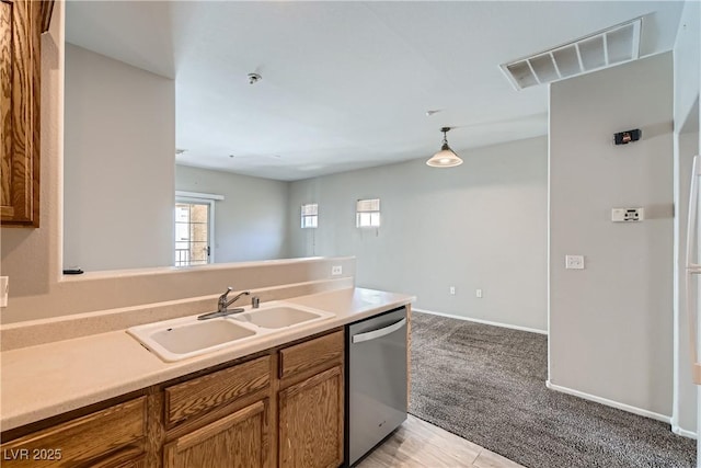 5915 Nuevo Leon St Unit 8, North Las Vegas, NV 89031 - kitchen featuring dishwasher, brown cabinetry, light carpet, and light countertops