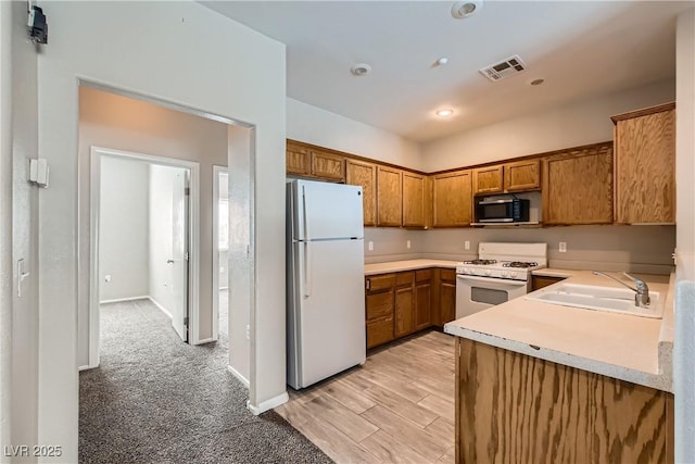 5915 Nuevo Leon St Unit 8, North Las Vegas, NV 89031 - kitchen with white appliances, brown cabinets, light countertops, and recessed lighting