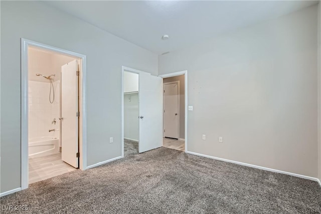 5915 Nuevo Leon St Unit 8, North Las Vegas, NV 89031 - unfurnished bedroom with light carpet, a walk in closet, and ensuite bathroom