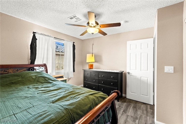 bedroom featuring wood finished floors, baseboards, a textured ceiling, and ceiling fan