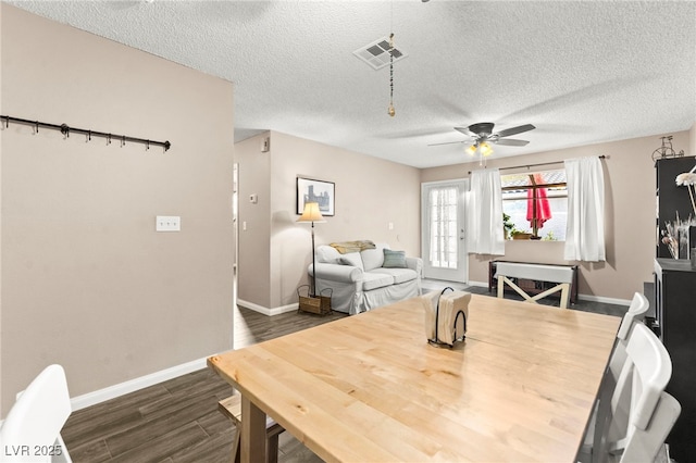 dining room featuring a ceiling fan, baseboards, dark wood-style floors, and a textured ceiling