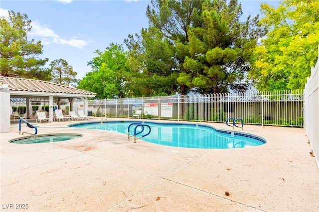 community pool with fence, a patio area, and a community hot tub