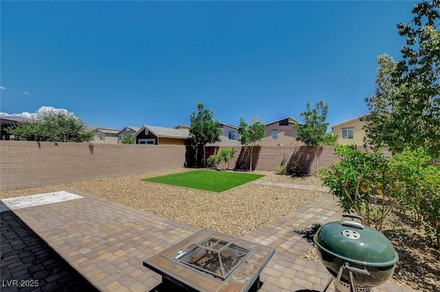 view of patio / terrace featuring a fenced backyard, an outdoor fire pit, area for grilling, and a residential view
