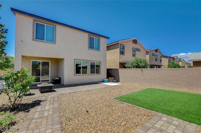 back of property featuring a patio area, stucco siding, and an outdoor fire pit