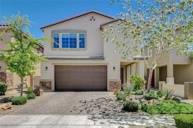 view of front of property with stucco siding, an attached garage, stone siding, and decorative driveway