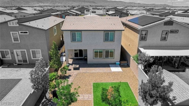 back of house with a residential view, a patio area, stucco siding, and a mountain view