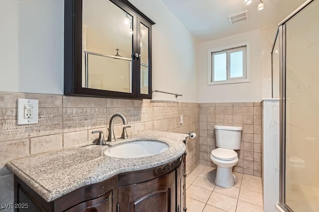 4302 Newhaven Dr, Las Vegas, NV 89147 - bathroom with tile walls, a shower stall, toilet, tile patterned floors, and vanity