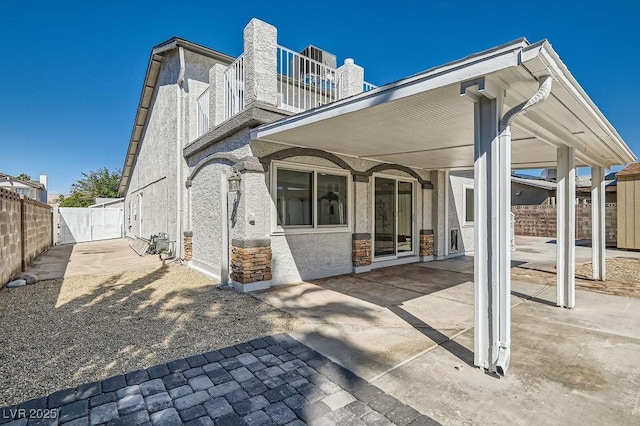 4302 Newhaven Dr, Las Vegas, NV 89147 - rear view of house with a gate, a patio, fence, a chimney, and stone siding