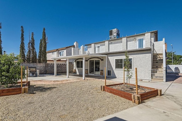 4302 Newhaven Dr, Las Vegas, NV 89147 - rear view of property featuring a vegetable garden, a patio, fence, stucco siding, and central AC