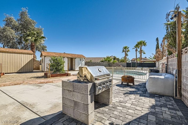 4302 Newhaven Dr, Las Vegas, NV 89147 - view of patio with a fenced backyard, an outdoor fire pit, an outdoor structure, a storage shed, and area for grilling