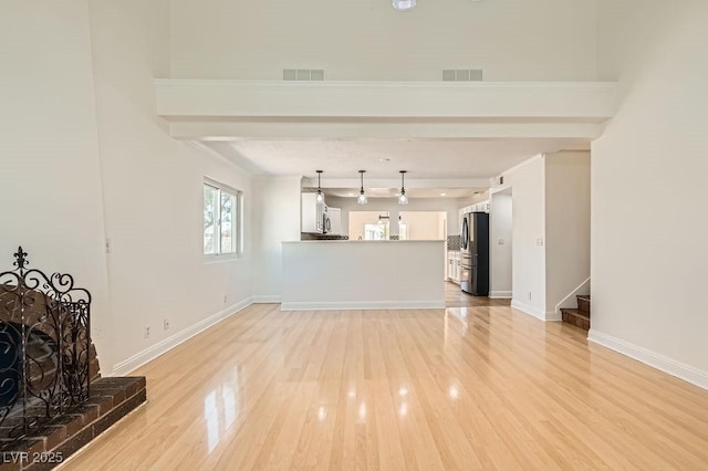 4302 Newhaven Dr, Las Vegas, NV 89147 - unfurnished living room featuring light wood-style flooring, stairs, baseboards, and beam ceiling