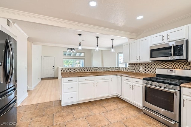 4302 Newhaven Dr, Las Vegas, NV 89147 - kitchen with stainless steel appliances, a peninsula, healthy amount of natural light, decorative backsplash, and ornamental molding