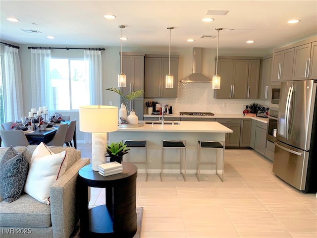 6511 Dove Point Pl, Las Vegas, NV 89130 - kitchen featuring stainless steel appliances, wall chimney exhaust hood, gray cabinetry, a sink, and light countertops