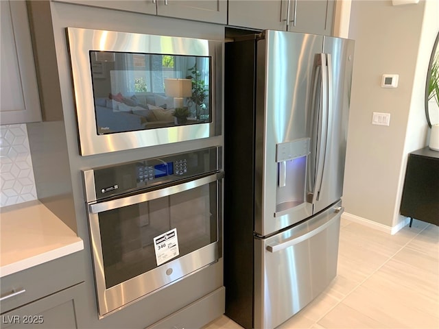 6511 Dove Point Pl, Las Vegas, NV 89130 - kitchen featuring stainless steel appliances, gray cabinetry, light countertops, light tile patterned floors, and baseboards