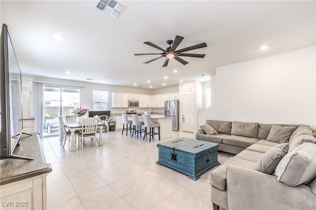 living area featuring ceiling fan, light tile patterned floors, and recessed lighting