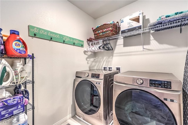 clothes washing area featuring washing machine and dryer and baseboards