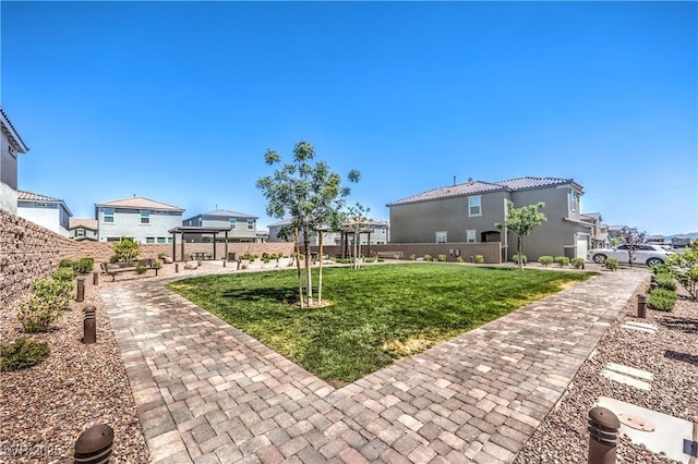 view of home's community with a lawn and a pergola