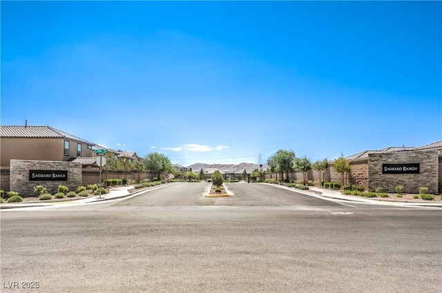 view of asphalt road with sidewalks, a residential view, and curbs