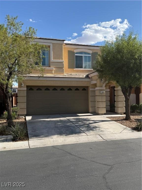 view of front facade with stucco siding, a garage, and concrete driveway