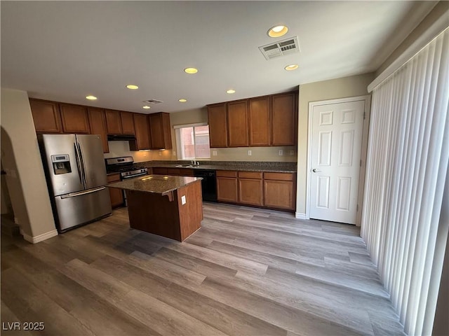 kitchen featuring appliances with stainless steel finishes, a center island, recessed lighting, under cabinet range hood, and a sink