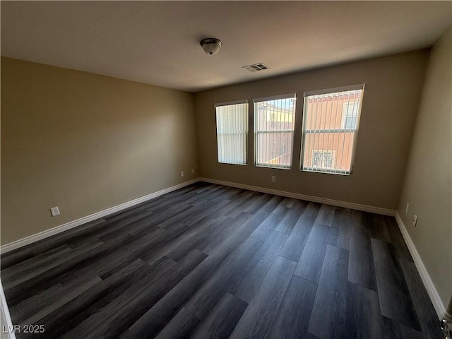 empty room with dark wood-type flooring and baseboards