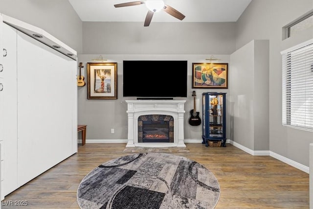 5421 Tourmaline St, Las Vegas, NV 89130 - living room featuring a ceiling fan, wood finished floors, a glass covered fireplace, and baseboards