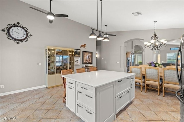 5421 Tourmaline St, Las Vegas, NV 89130 - kitchen featuring arched walkways, ceiling fan, white cabinets, vaulted ceiling, and light countertops
