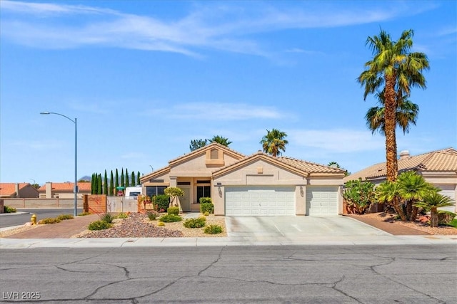 5421 Tourmaline St, Las Vegas, NV 89130 - view of front of home with a garage, concrete driveway, stucco siding, a tiled roof, and fence