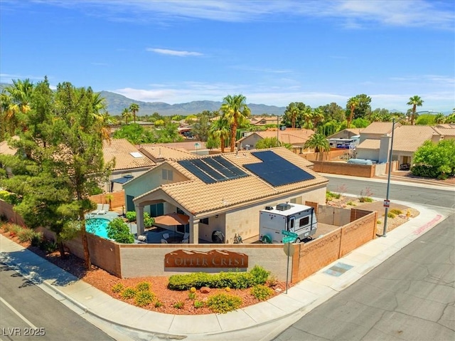 5421 Tourmaline St, Las Vegas, NV 89130 - view of front of house featuring fence, roof mounted solar panels, a tile roof, a mountain view, and stucco siding