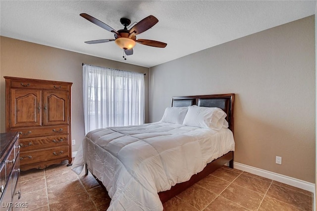 bedroom featuring baseboards, a textured ceiling, ceiling fan, and tile patterned flooring