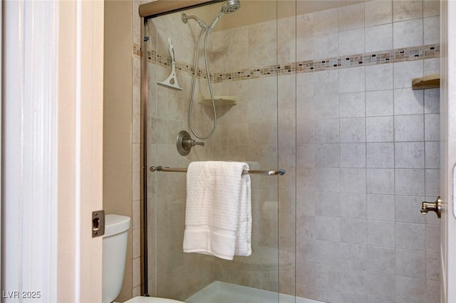 full bathroom featuring a stall shower and toilet
