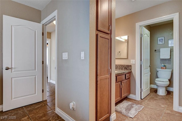 bathroom with tile patterned floors, toilet, vanity, and baseboards