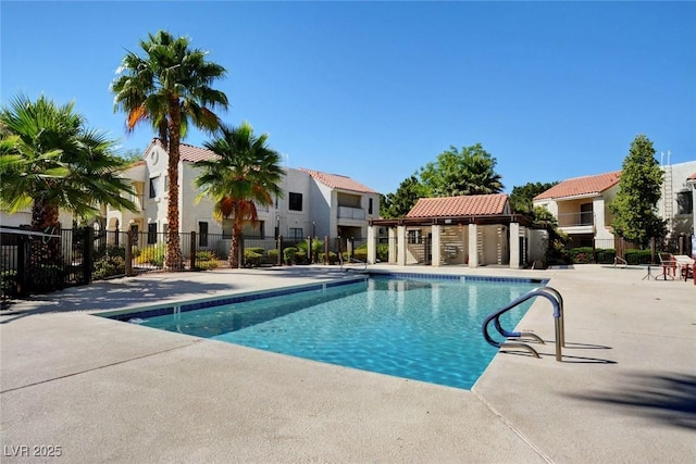 community pool with fence, a residential view, and a patio