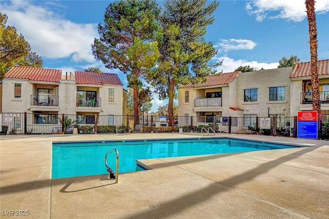 community pool featuring fence and a patio area