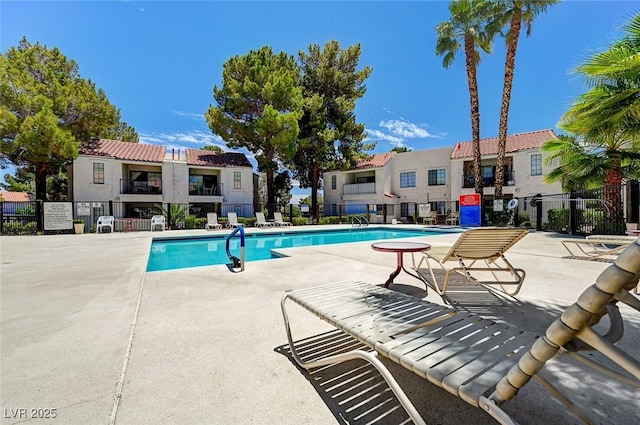 community pool with fence and a patio