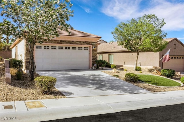 view of front of home with a tiled roof, stucco siding, driveway, stone siding, and an attached garage