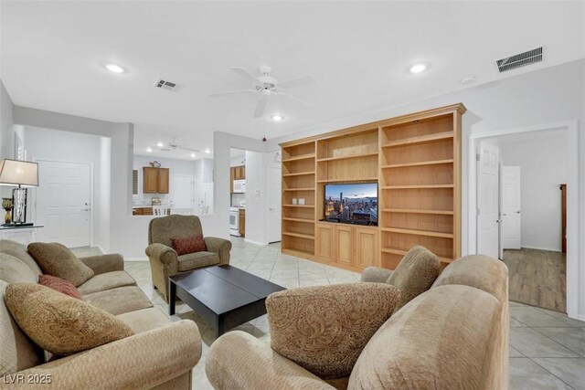 living area featuring recessed lighting, a ceiling fan, light tile patterned flooring, and baseboards